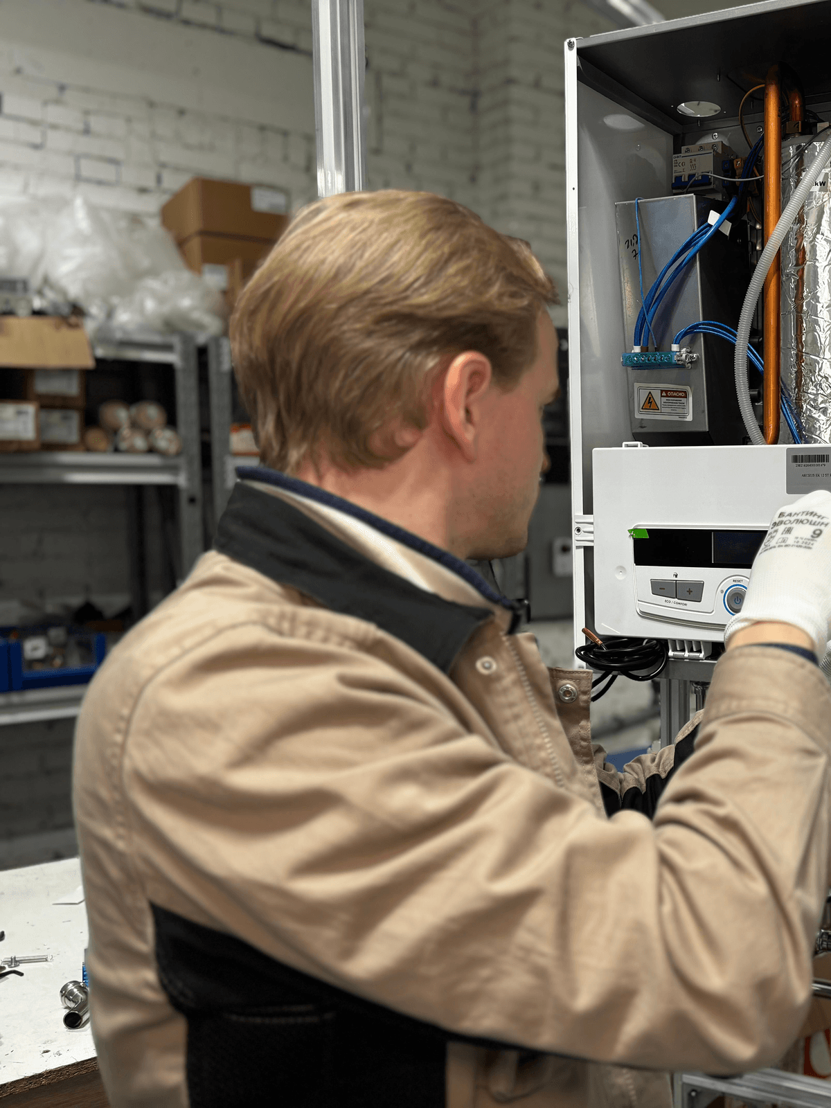 Technician checking heating equipment and exposed controls.